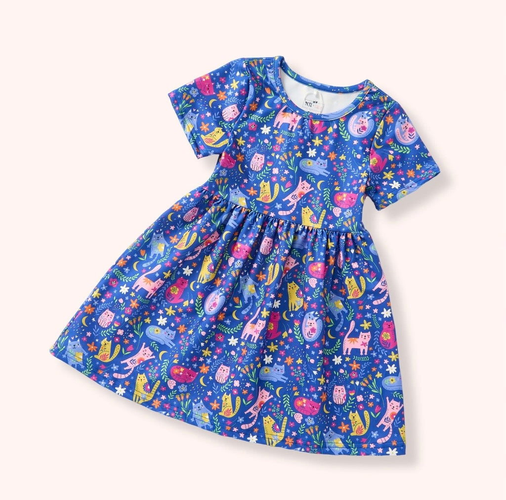 Meow Magic Dress — vibrant blue allover cat and floral print dress with short sleeves and gathered skirt