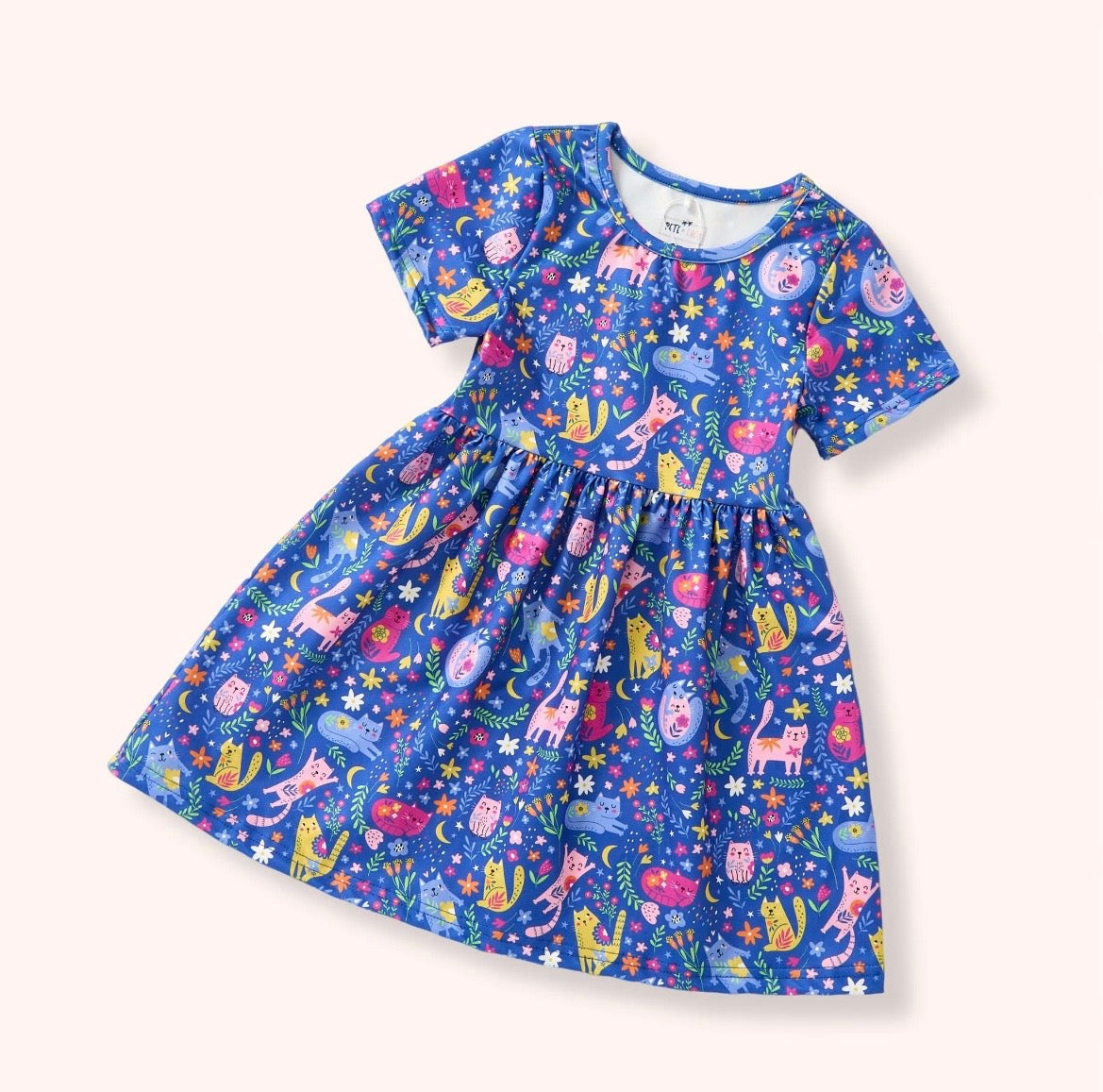 Meow Magic Dress — vibrant blue allover cat and floral print dress with short sleeves and gathered skirt