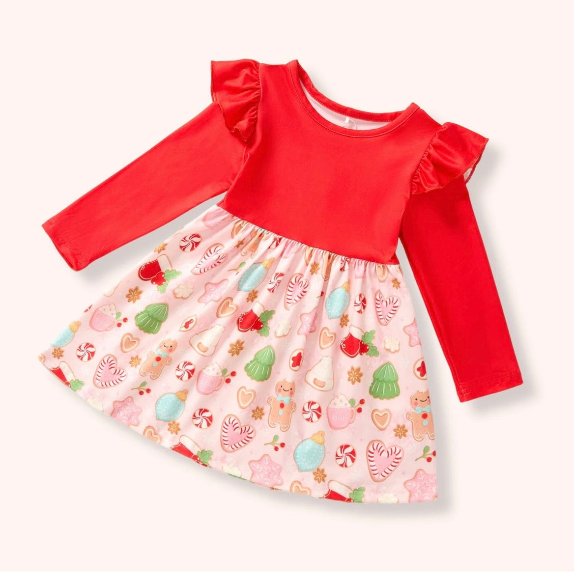 Christmas Cookies Dress with red long sleeves, ruffled shoulders, and a light pink skirt printed with gingerbread cookies and peppermint treats.